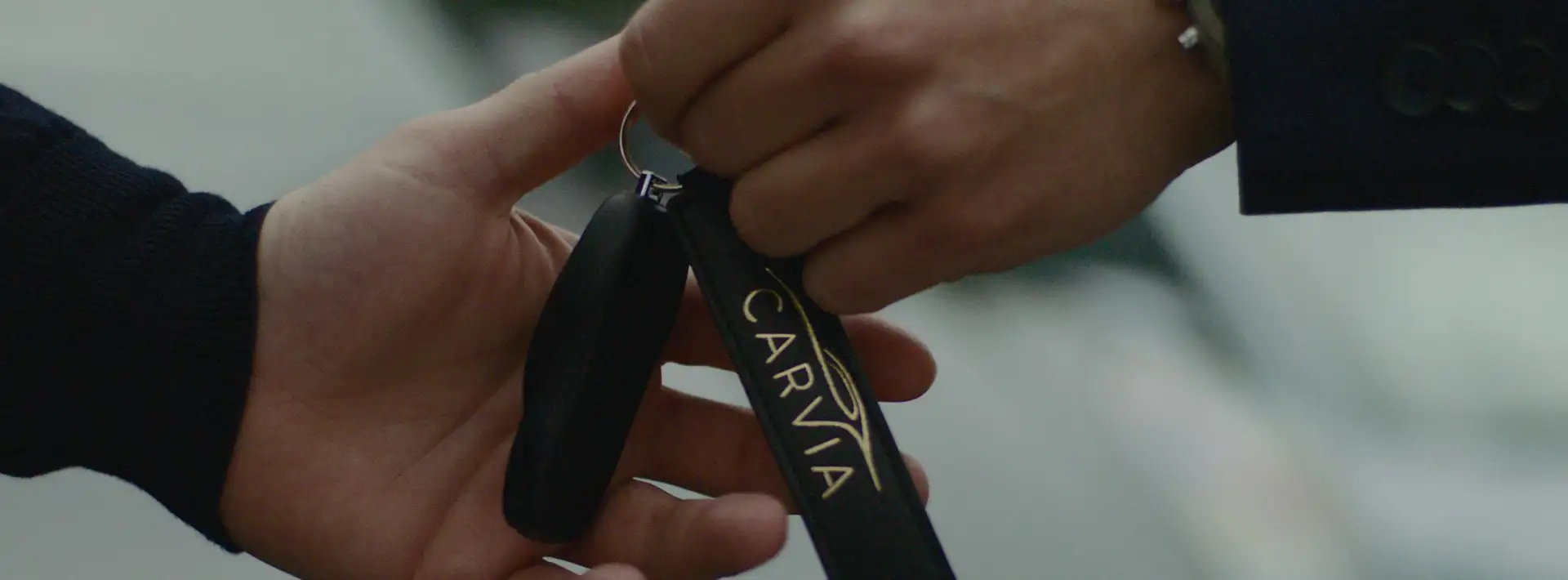 A CarVia employee hands over the keys to a rental car.